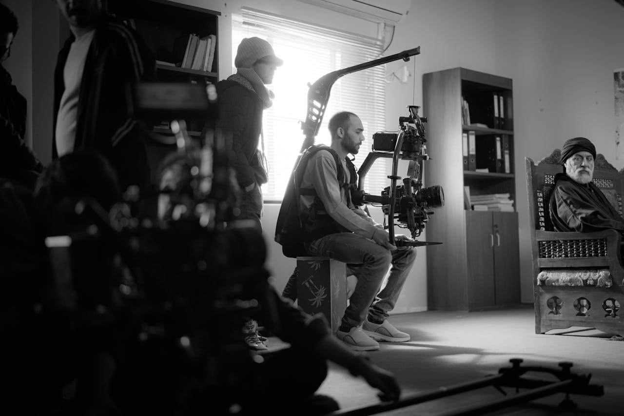 cta-bg Black and white photo of a film crew working indoors with high-end camera equipment.