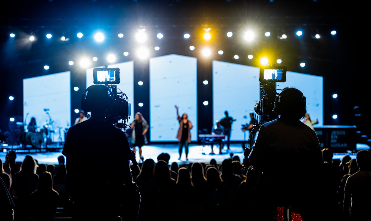 home-services-01 Energetic live concert scene with cameramen filming the vibrant stage performance.